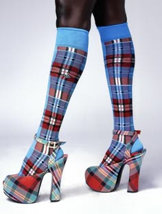 a person wearing a pair of blue and red plaid socks with matching high heels, their legs are bare except for the socks.