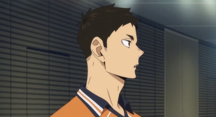an anime character with brown hair and brown eyes is shown in a closeup. they are wearing an orange and white jersey with blue stripes. the background is a wall with blinds. the character has a serious expression on their face.