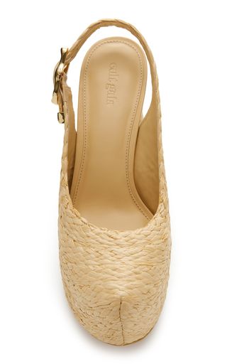 a close up view of a pair of beige woven straw slingback heels.  the shoes have a comfortable summery vibe and are perfect for casual or dressy occasions.  they are trendy and chic.