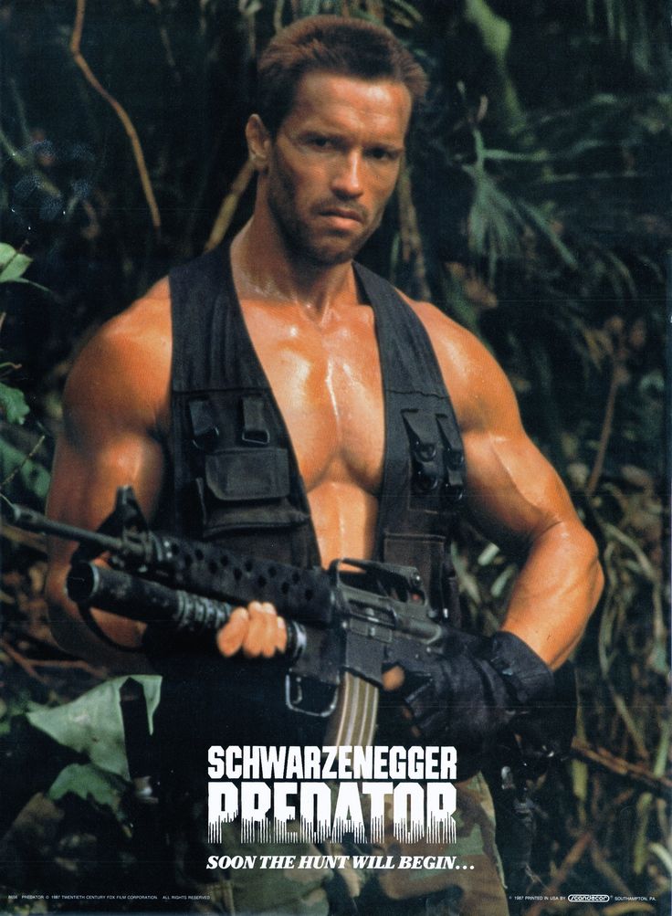 this is a poster for the movie "predator" (1987) featuring arnold schwarzenegger as the character dutch. the poster shows arnold schwarzenegger in a jungle setting, wielding a large assault rifle and wearing camouflage clothing and a black vest. the poster title reads "schwarzenegger predator", with the tagline "soon the hunt will begin...".