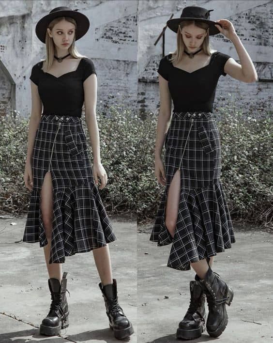 he image shows two identical photos of a young woman posing outdoors. she is wearing a black sweetheart neckline top, a black and white plaid asymmetrical mermaid skirt with a side slit, a black hat, and black combat boots.  the style is gothic and punkinspired. the setting appears to be an urban street with a stone wall in the background. the photos are mirrored, showing the model from slightly different angles.