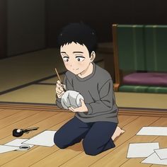 a young boy with short black hair kneels on a wooden floor. he's deeply engrossed in painting a small, white, round object, possibly a daruma doll, using a thin brush. scattered around him are pieces of white paper, suggesting a dedicated workspace for his artistic endeavor. the lighting is gentle and warm, emanating from an unseen source, perhaps a nearby lamp, casting a cozy atmosphere. the overall ambiance suggests a peaceful moment of creative absorption.