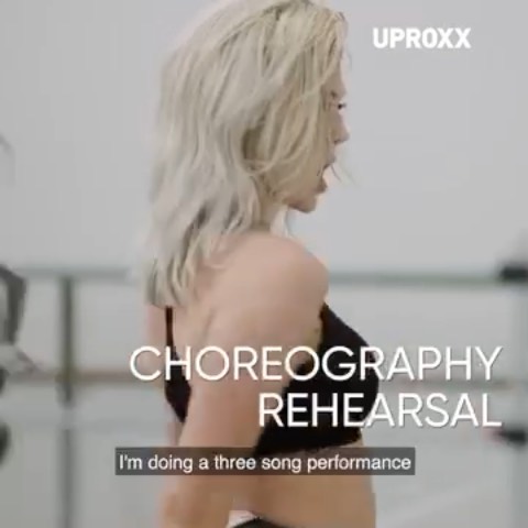 a woman with blonde hair is seen in profile, rehearsing choreography for a three song performance. the word "choreography rehearsal" is superimposed on the image, along with the uproxx logo.