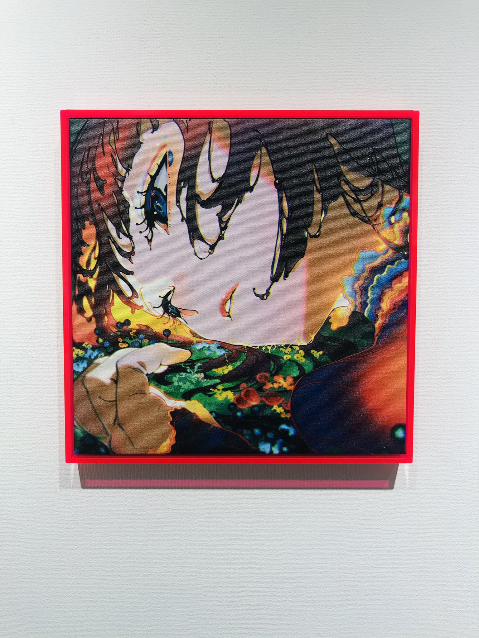 a vibrant animestyle portrait of a woman with short, dark hair. she is gazing downward with a contemplative expression. the artwork utilizes bold colors and patterns, including floral motifs on her clothing. it is displayed in a bright red frame against a white wall.
