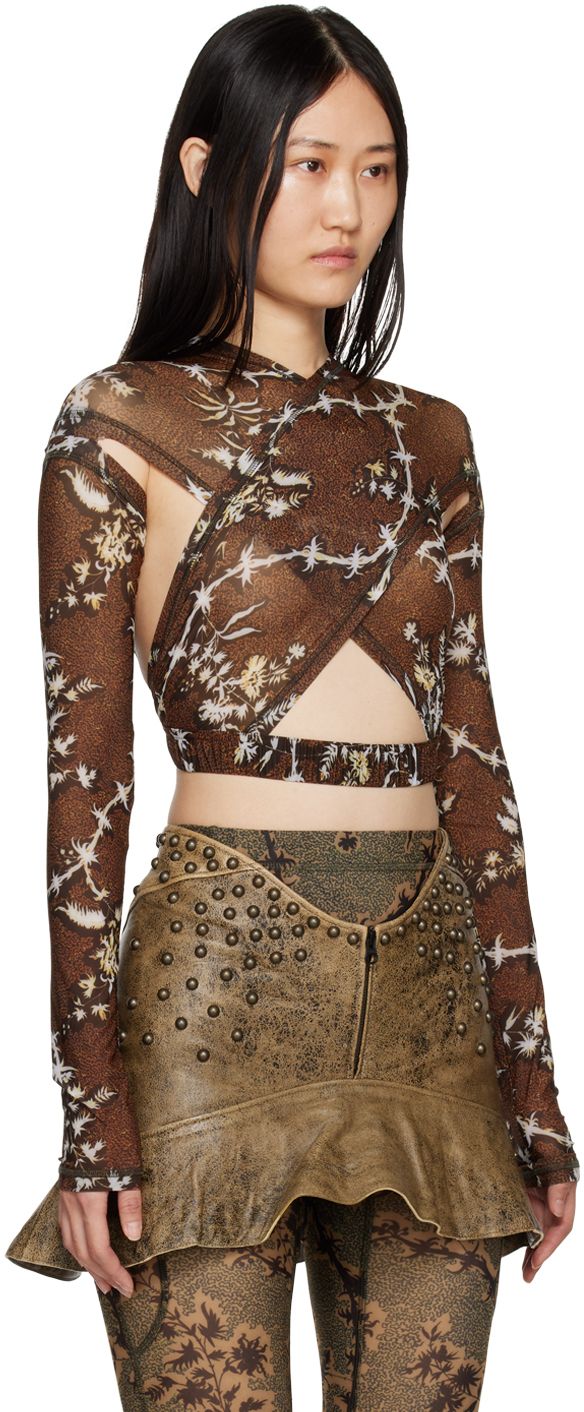 a woman is wearing a brown floral printed longsleeve mesh top with a brown leather skirt.