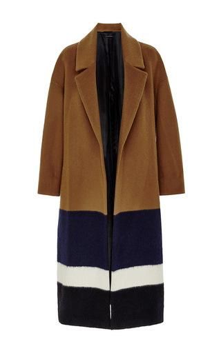 a women's long, colorblock wool overcoat, with the top section being brown, followed by a block of navy blue, white, and black. the coat has a traditional lapel and is unbuttoned. the lining appears to be black.