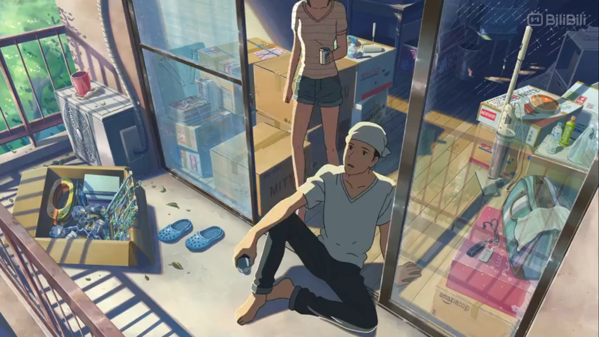 the image depicts a man and a woman on a cluttered balcony of an apartment, seemingly in the middle of moving. cardboard boxes filled with belongings are scattered around, along with other household items. the man sits on the balcony floor, drinking from a can while looking out. the woman stands inside, partially obscured by the window, holding a drink and looking down. the scene is bathed in warm, natural light streaming in from the open balcony door, casting long shadows across the space. the overall atmosphere suggests a sense of transition and the mundane yet significant moments of everyday life.