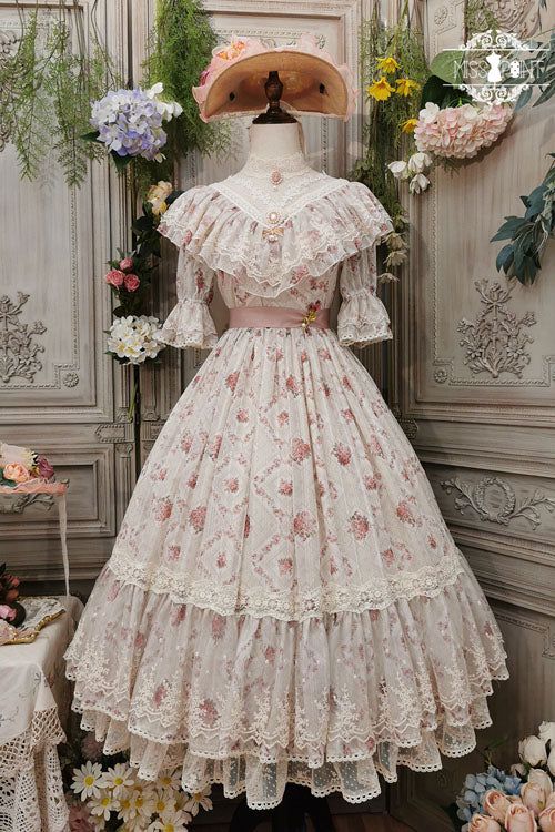a creamcolored lolita fashion dress with a floral pattern is displayed on a mannequin. the dress has a square neckline, ruffled sleeves, and a full skirt with multiple layers of lace. the mannequin is wearing a matching hat and a pink ribbon around its waist. the background is decorated with flowers and a floral wallpaper.
