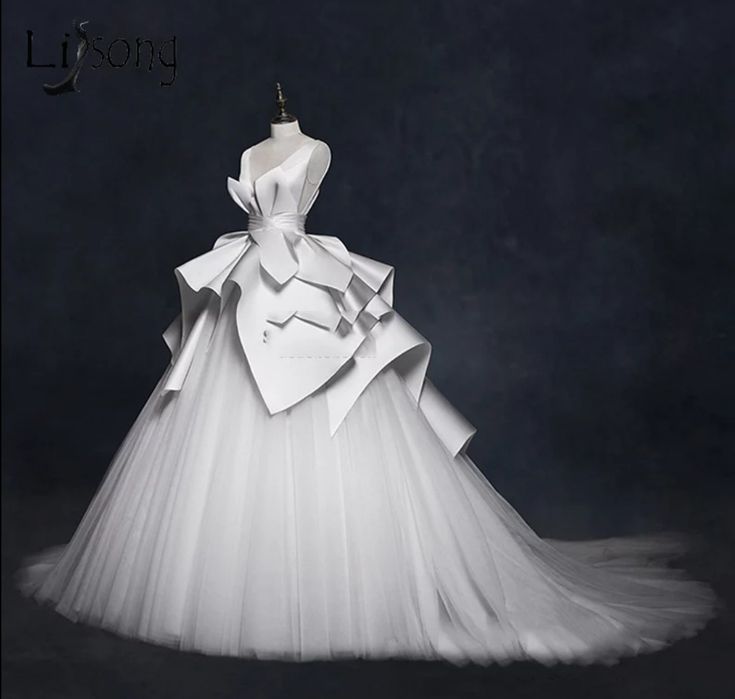 a gorgeous white wedding dress with a voluminous tulle skirt and a dramatic, structured bodice. the bodice is made of silk and satin, with a sweetheart neckline and a ruched design. the skirt is layers of tulle and silk, creating a flowing, princesslike silhouette. the dress is elegant and romantic, perfect for a fairytale wedding.
