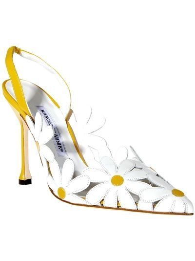 a manolo blahnik slingback heel with a daisy pattern. the shoe is primarily white with yellow accents on the heel and the center of the daisies.