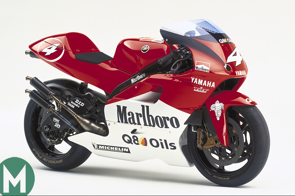 a yamaha yzr500 race bike with marlboro sponsorship livery. the bike is in red and white with the marlboro logo and q8 oils logo. the bike has michelin tires and a number 4 on the side.