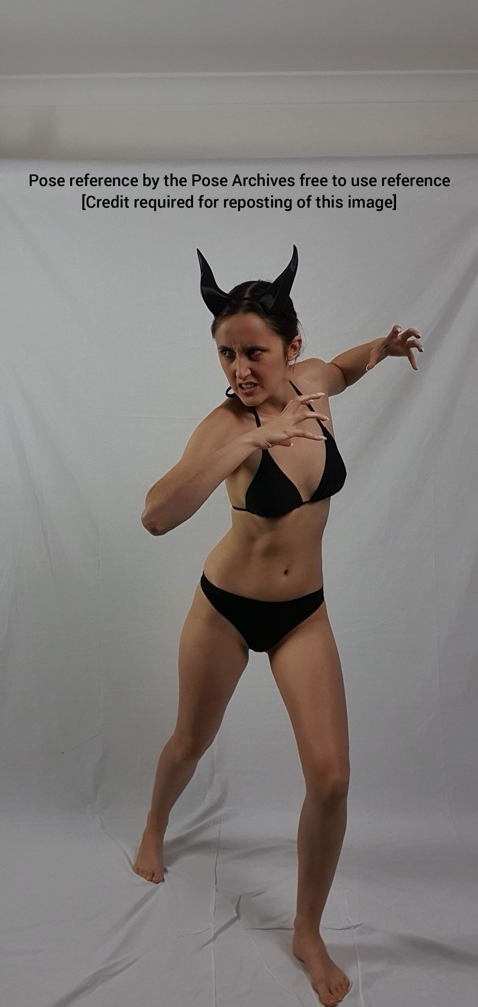 a woman wearing black bikini bottoms and devil horns strikes a dynamic pose against a white backdrop. the image is intended as a reference for artists.