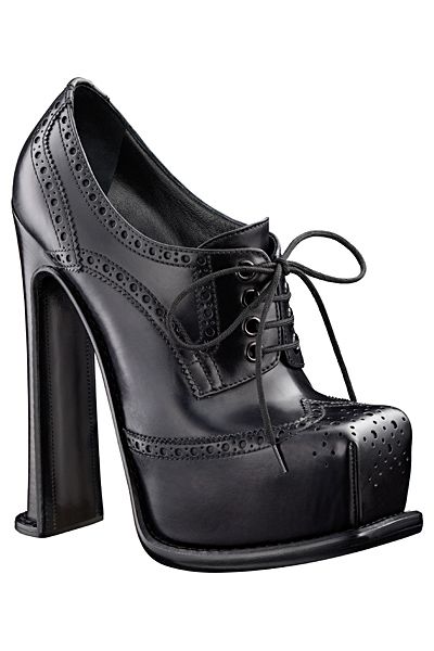 a black, laceup platform shoe with a high block heel, featuring brogue detailing.