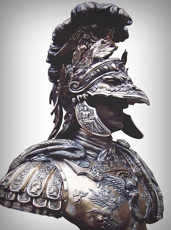 a bronze bust of a roman soldier in ornate armor. he wears an elaborate helmet adorned with a plume and reliefs. the breastplate is also intricately detailed with scenes of figures and eagles.