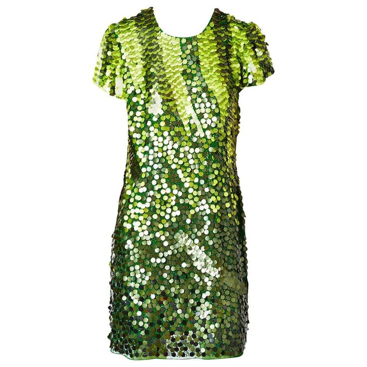 a green sequin dress with short sleeves and a round neckline. the dress is made of small, round sequins that are sewn onto a mesh fabric. the sequins are a variety of shades of green, creating a shimmery effect. the dress is fitted through the bodice and flares out slightly at the hem. the model is wearing the dress with her hair styled in a sleek, straight bob. the dress is perfect for a party, evening out, or a special occasion.