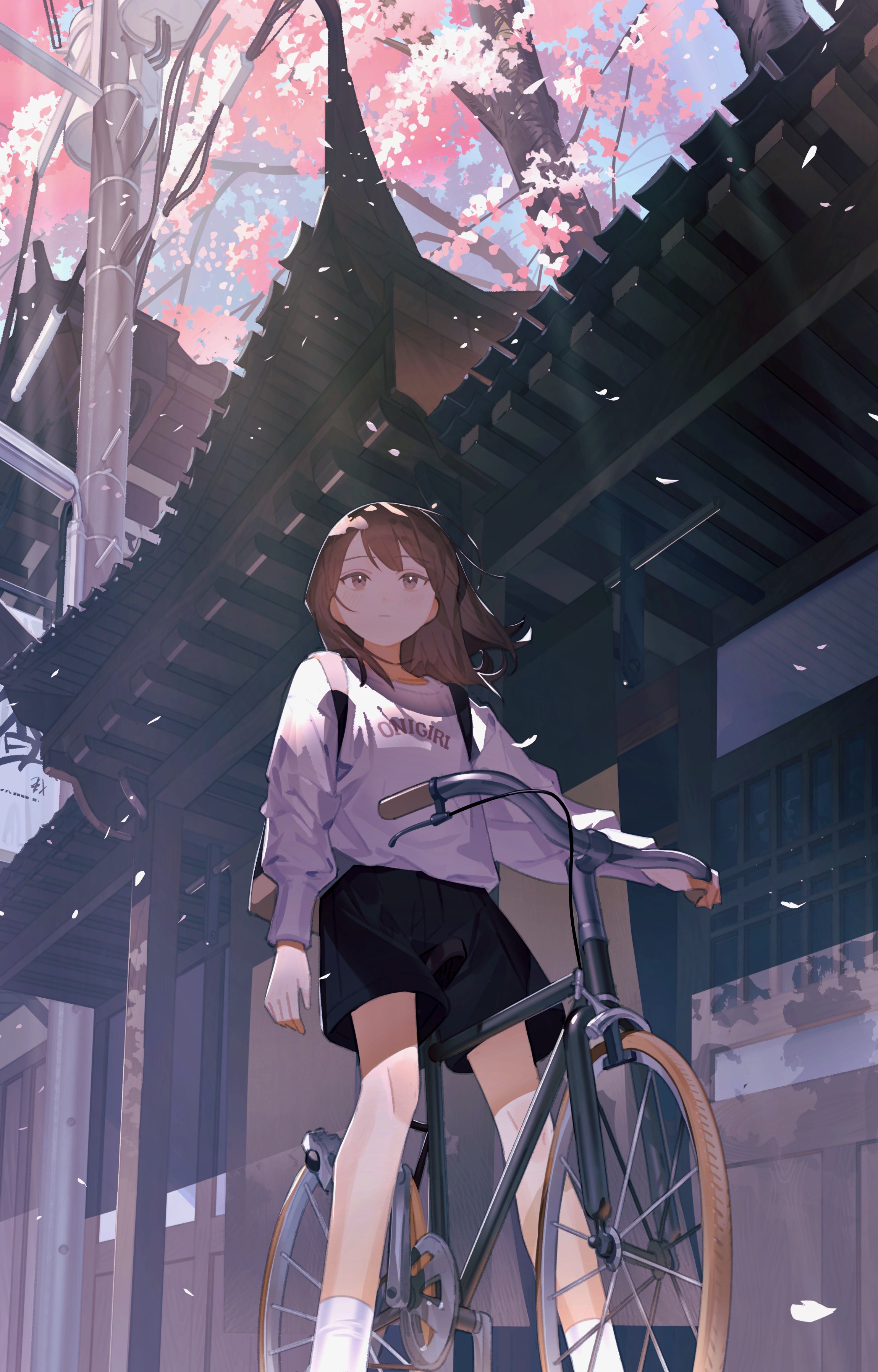 the image depicts an animestyle girl with brown hair, wearing a pastel purple sweatshirt and dark shorts, riding a bicycle under a blossoming cherry tree. the setting is a charming, seemingly japanese street, with traditional architecture visible in the background. the overall style is soft and pastel, with a focus on delicate details like the falling cherry blossoms and the girl's expressive eyes. the low angle perspective enhances the sense of scale and draws attention to the girl and her surroundings.  the scene is peaceful and idyllic, conveying a sense of springtime and youthful energy.