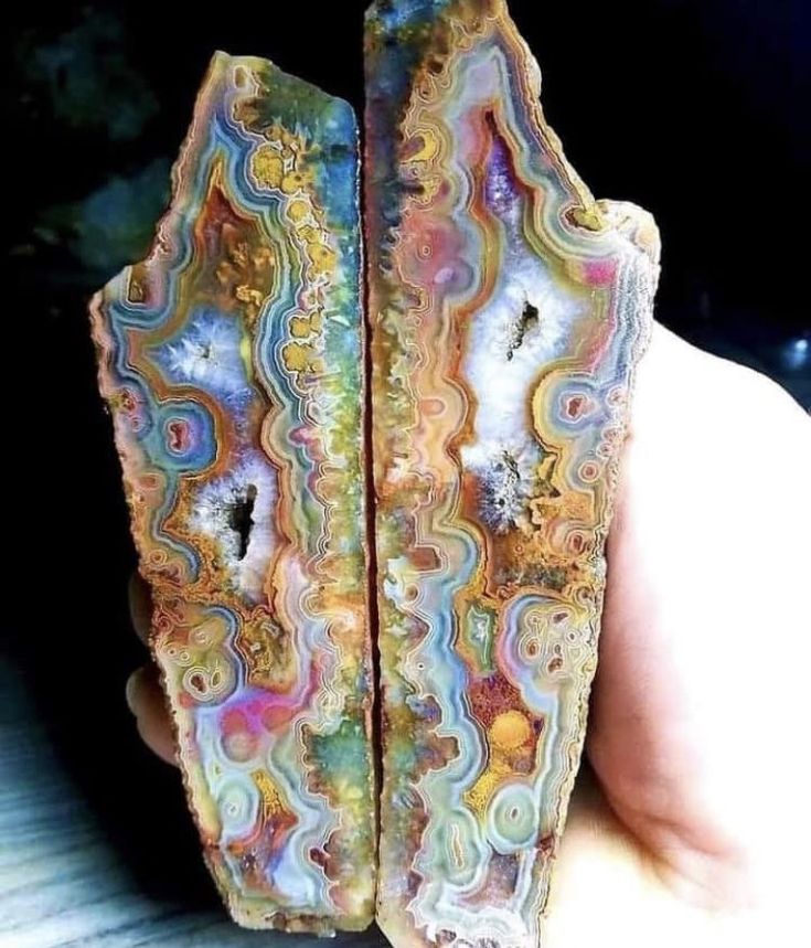 a closeup shot of a beautiful agate geode with vibrant and intricate patterns in a rainbow of colors. the agate is polished smooth and shines under the light, revealing the delicate patterns of the gemstone.