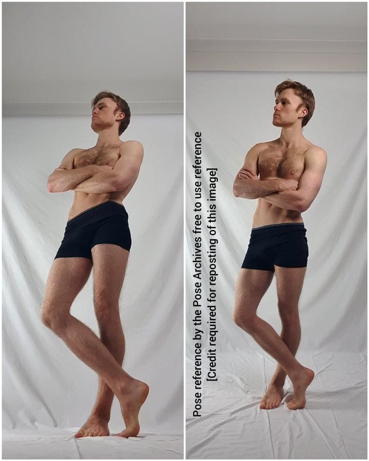 this image shows a man standing in a studio. he is wearing black shorts and is posing with his arms crossed. the background is white.