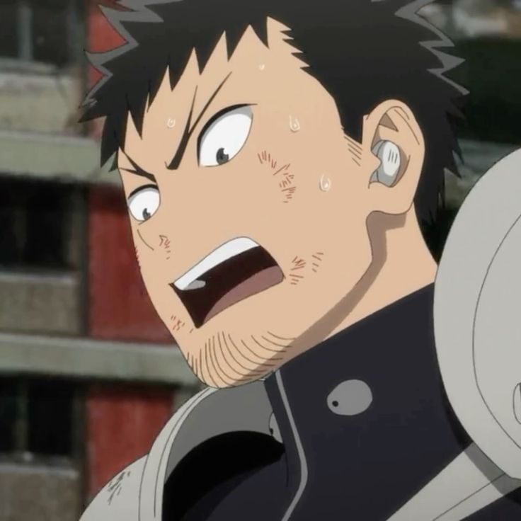 this is a closeup image of an anime man who is sweating and appears stressed. his mouth is open like he's yelling and there are scratches on his face. he is wearing a white and dark blue jacket. the background is blurry, but shows a red building.