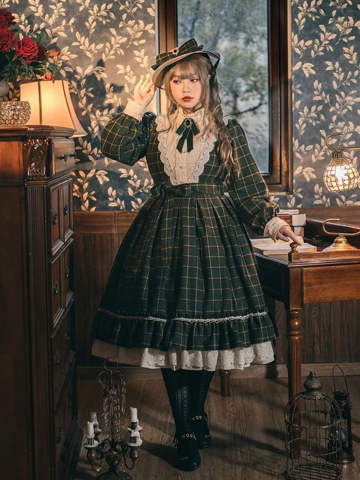 a young woman in a vintageinspired green plaid dress is posing in a room with dark, ornate furniture and patterned wallpaper. the dress features lace trim, a high collar, and long sleeves. she's also wearing a matching hat and black boots. the scene is lit by artificial light, creating a warm and inviting atmosphere.