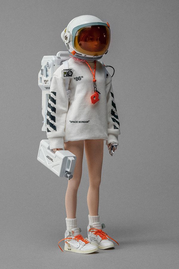 a white astronaut doll figure wearing an offwhite sweater and orange sneakers. the doll has a backpack and is holding a white gas can.