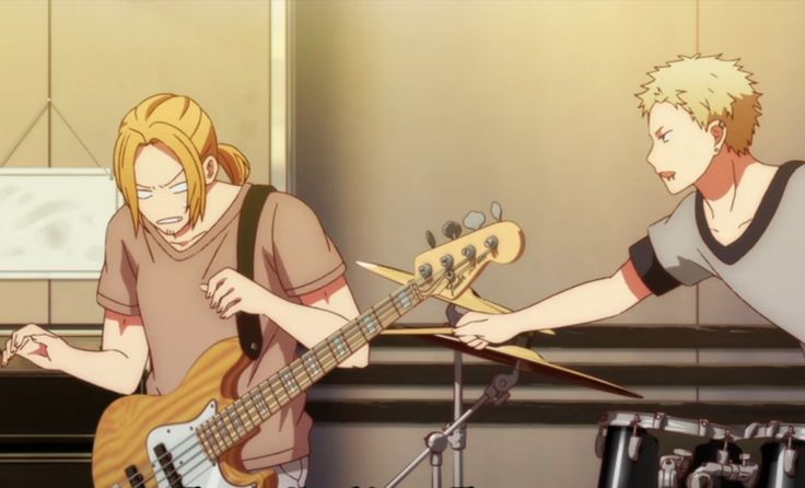 two anime boys are playing music together. the one on the left is playing a bass guitar and the one on the right is playing drums. the one on the left is concentrating on the bass, looking serious, while the one on the right is smiling as he plays. they seem to be enjoying the music together. the image is set in a room that looks like a practice space for a band. there are musical instruments in the background and a microphone on a stand. the image is bright and colourful and has a youthful feel.