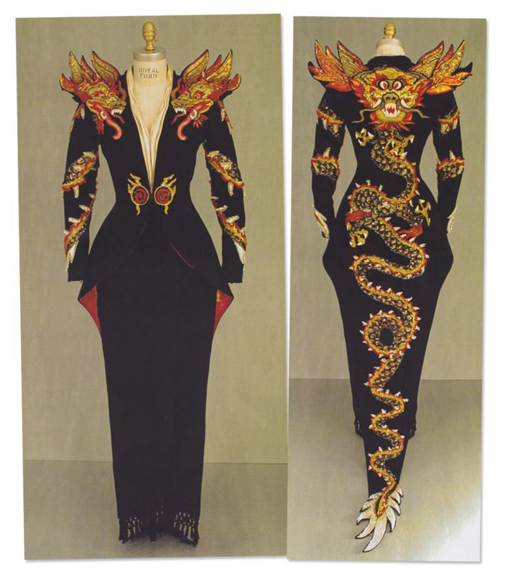 the image shows two views (front and back) of a long black dress displayed on mannequins. the dress features intricate embroidery, notably designs of dragons in gold, red, and white. the dress has structured shoulder pads resembling dragon heads and a floorlength skirt. red accents are visible at the sides of the dress. the back view showcases a winding dragon design along the length of the dress.