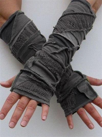 a pair of grey fingerless gloves, knitted with fabric, with a trendy style that is perfect for the winter season. they are worn on the arms and are perfect for keeping your hands warm while still allowing you to use your fingers.