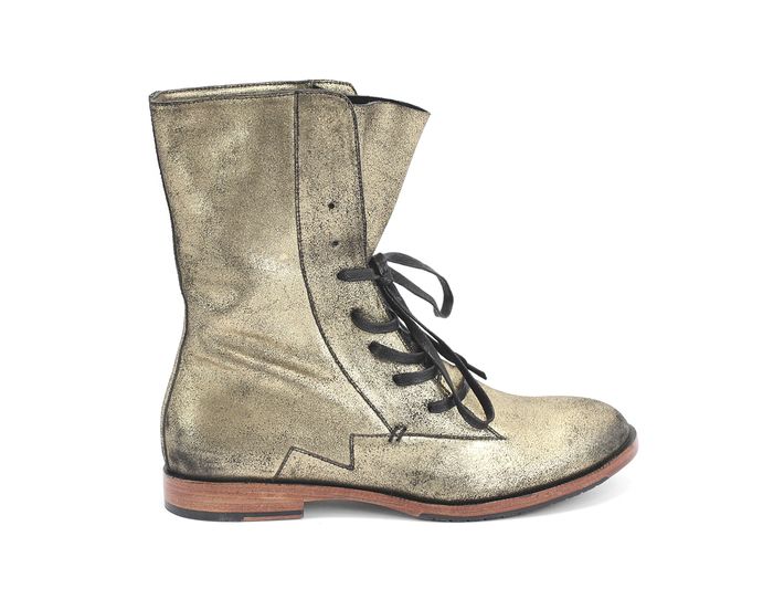 a gold leather ankle boot with laceup fastening is isolated on a white background.