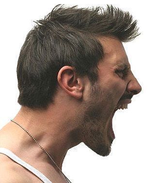 a profile shot of a man screaming, with his mouth wide open. he has a beard and is wearing a chain and tank top. he appears to be angry or in a state of rage.