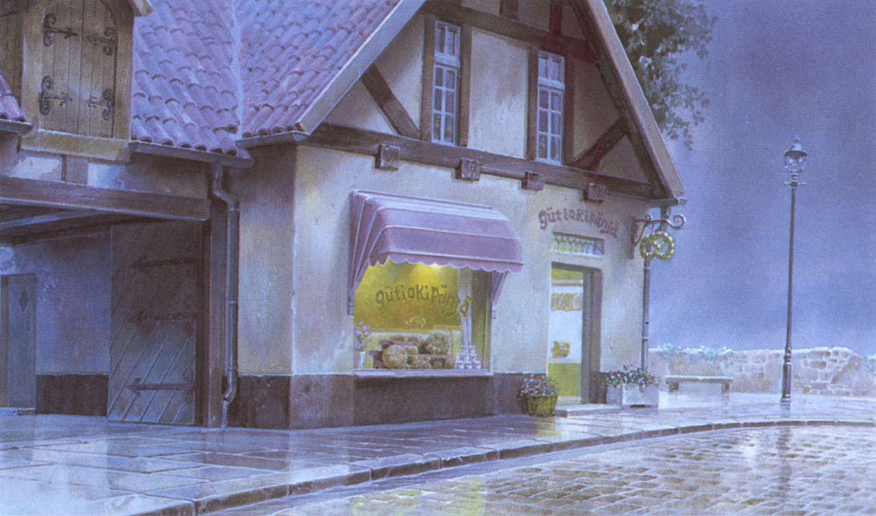 a quaint bakery on a cobblestone street at night. the scene is lit by a streetlamp, and the wet pavement reflects the light. the bakery has a display window filled with baked goods and a pink awning. there are flower pots near the entrance. the building has a halftimbered facade and a tiled roof.