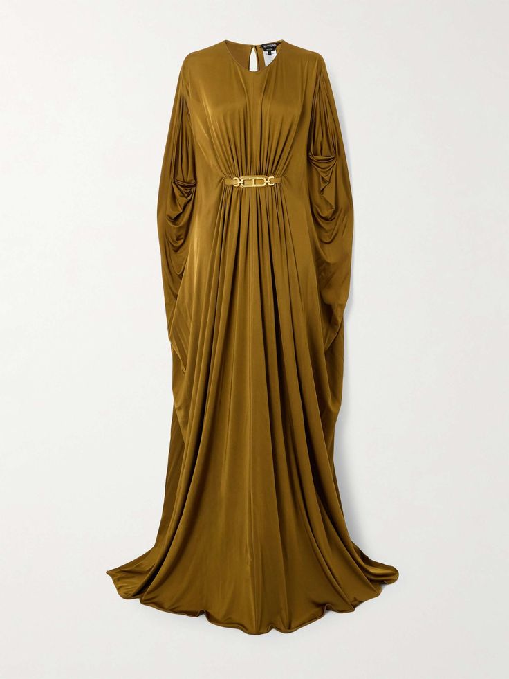 a long gold dress with long sleeves, a flowing silhouette, and a simple design, perfect for a formal event or special occasion. the dress is elegant and chic, and the smooth fabric drapes beautifully.  the model is standing on a white background.