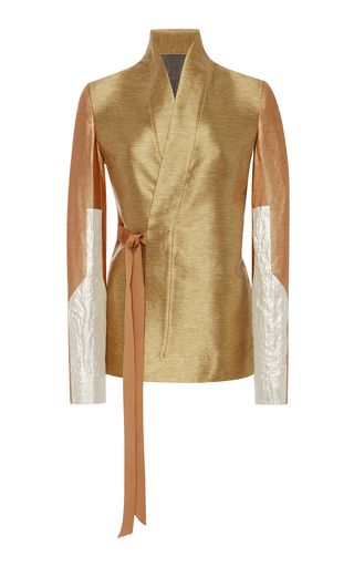 a gold and beige kimonostyle jacket with long sleeves and a sash. the jacket is made of a shiny textile and has a vneckline. the sleeves are twotoned, featuring gold and beige sections, and the jacket is secured with a brown sash.