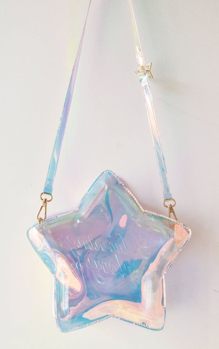 the image features a holographic, starshaped purse hanging against a white background. the purse has a shoulder strap and iridescent colors.