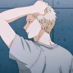 an animestyle illustration of a young man with short blonde hair and multiple earrings leaning against a blue wall. the drawing is from the waist up and focuses on his side profile, with his hand resting atop his head. he's wearing a plain gray tshirt. the lighting is soft and gives the image a calm atmosphere.