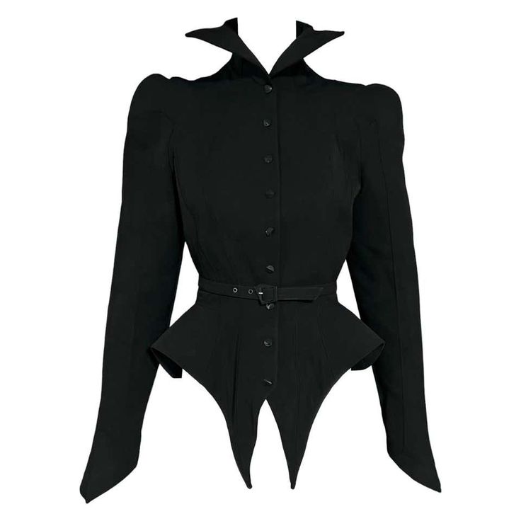 a black, longsleeved, buttonup blouse with a fitted bodice, and a high collar. the blouse has a pointed hemline and is cinched in at the waist with a belt. it is a vintage style, high fashion piece of clothing.