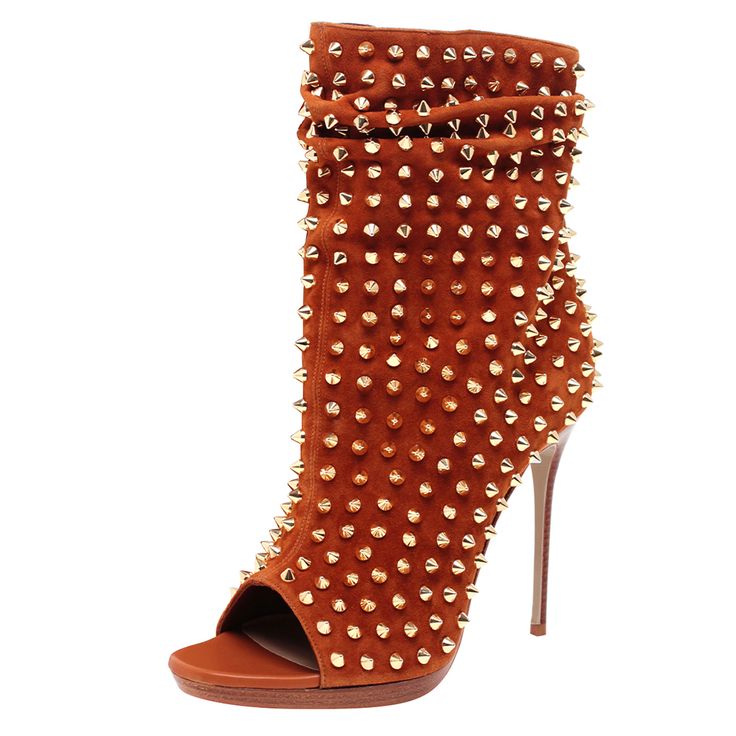 the image showcases a pair of women's ankle boots.  the boots are made of orange suede and are heavily studded with goldcolored pyramidshaped metal studs across the entire surface.  they feature a peeptoe design, a high stiletto heel, and a slightly slouchy or gathered upper. the sole appears to be a platform style.  the overall style is glamorous and edgy. the boots are presented against a plain white background.