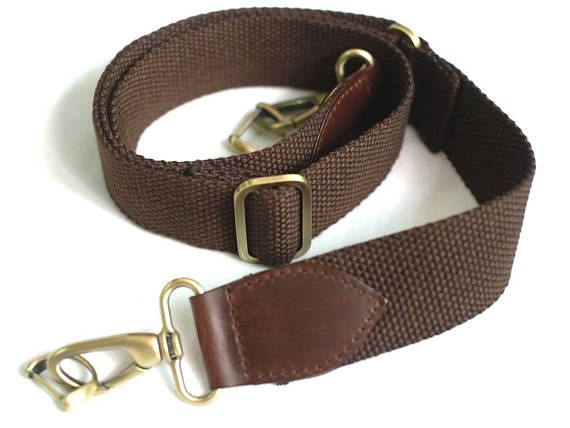 this is a brown camera strap made of leather and canvas. it is adjustable, with metal buckles for fastening. the strap is durable and stylish, perfect for any camera enthusiast.