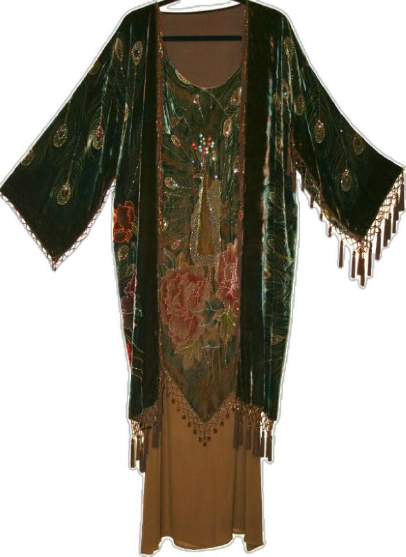 this image showcases a luxurious vintage bohemian evening gown featuring a peacock design and floral embroidered details on velvet. the gown is embellished with sparkling beads and has intricate beaded fringe adorning the sleeves and hem. the peacock design, floral accents, and overall glamorous aesthetic contribute to its luxurious and eyecatching appeal.