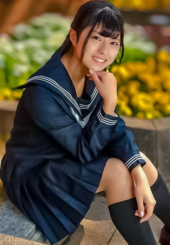 the image shows a young woman wearing a japanese school uniform, seated outdoors in what appears to be a garden. she is smiling and looking directly at the camera. the lighting is warm and natural, suggesting a sunny day.