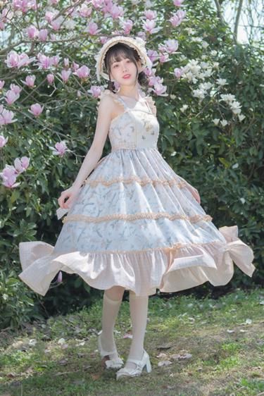 a young asian woman wearing a flowing floral lolita dress and a straw hat is standing in a garden. she is surrounded by blooming magnolia trees. the dress is white with a pink and green floral pattern and has multiple layers of ruffles. she is also wearing white socks and mary jane shoes. the lighting is bright and natural, and the perspective is from eye level.