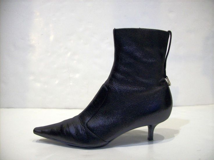 a single black leather ankle boot with a pointed toe and stiletto heel is positioned against a white background.