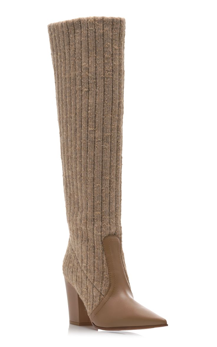 a pair of women's kneehigh boots are displayed against a white background. the boots are a light beige color and feature a knitted upper that extends to the top of the boot.  the lower part of the boots, from the ankle down, is made of smooth leather, which forms the pointed toe. the boots have a block heel.  the overall style appears elegant and suitable for autumn or winter.