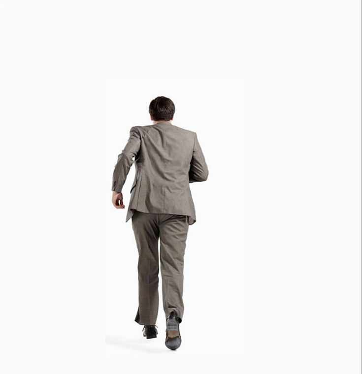 a businessman in a grey suit is walking away from the camera. he is walking on a white background and is wearing black shoes.