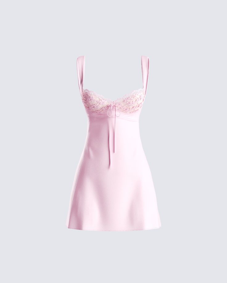 a light pink mini dress with straps and a sweetheart neckline. the dress is made of a silky material and has a lace trim. the neckline has a ribbon tie. the dress is perfect for a summer party.