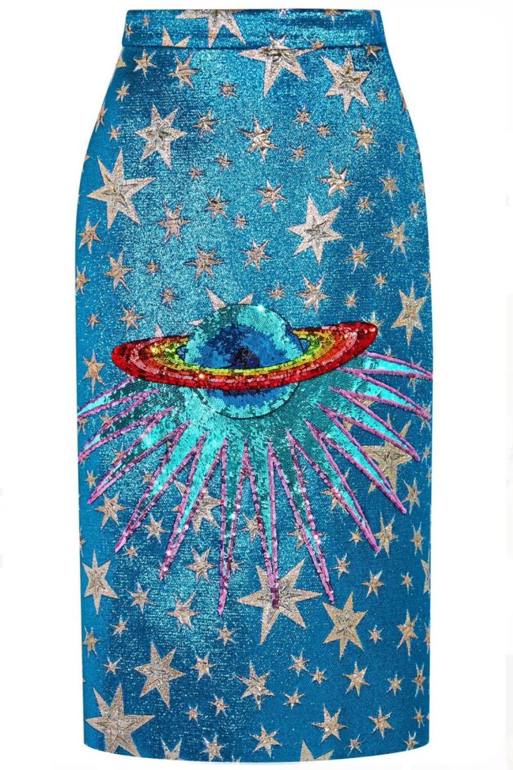 this is a closeup image of a woman's skirt. the skirt is made of a blue fabric that has a pattern of stars, the skirt is also covered in sequins. in the middle of the skirt is a large, embroidered design of a planet with a ring around it, the ring is a rainbow color. the skirt is a very eyecatching and glamorous piece of clothing.