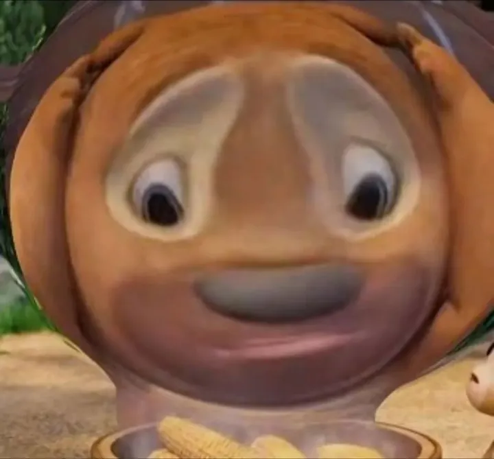 the image shows a cgi animation of a dog's face, heavily distorted and stretched. the dog's eyes are wide and looking directly at the viewer. the dog appears to have a bowl of corn in front of it. the overall image is surreal and humorous.