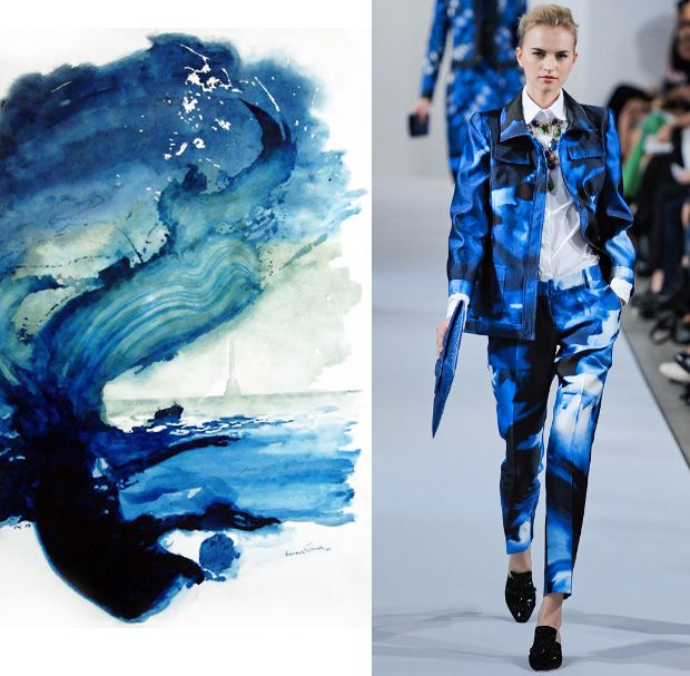 the image is a split image. the left side shows a watercolor painting of a blue wave with a touch of green and a view of the sea and the sky in the background. on the right side, a female model is walking on a runway, showcasing a stunning blue suit with a white shirt and black shoes. the suit design is inspired by the watercolor painting. the model is wearing a white shirt underneath the suit and a necklace that adds to the overall stylish look.