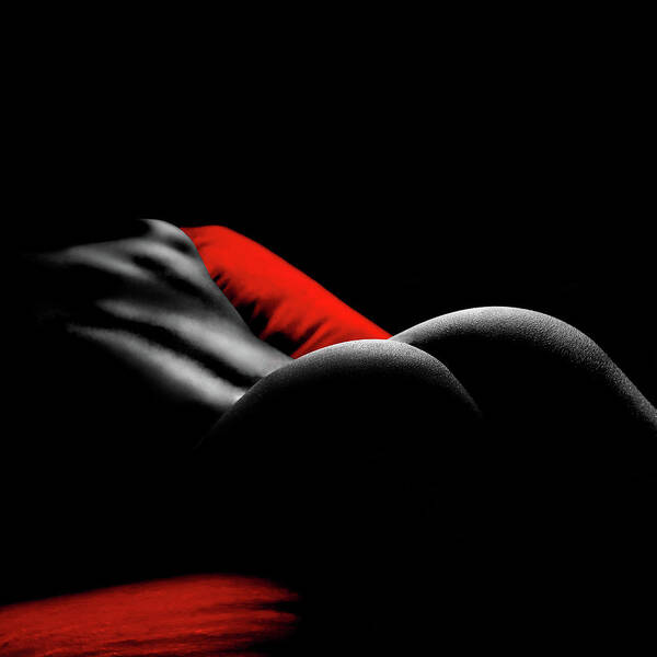 the image is a stylized black and white photograph, with selective color used to highlight a red pillow or sheet.  it features the back and buttocks of a woman's body, partially obscured by shadow and lowkey lighting. the overall mood is sensual and intimate, focusing on the form and curves of the female body. the dark background and the strong contrast between the black and red emphasize the subject's shape. the image has an artistic and provocative quality.