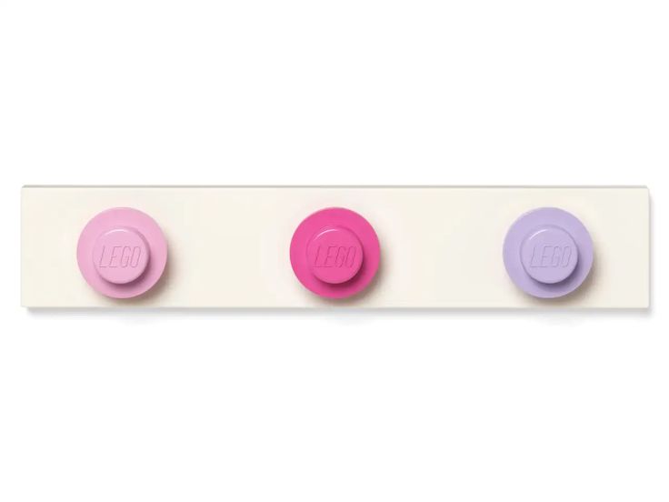 the image shows a lego wall hanger with three circular mounting pieces in pink, bright pink, and light purple, attached to a long rectangular board. the lego logo is visible on each of the circular mounts.